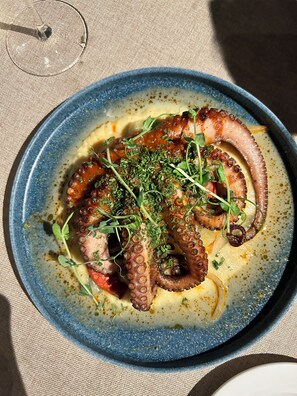 A plate of octopus with herbs, served on a blue plate. - LUXURY TWO BEDROOM PRESIDENTIAL SUITE at Grand Solmar Land’s End Cabo San Lucas (Cabo San Lucas)