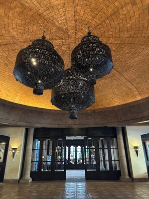 A spacious lobby with a high arched ceiling and a large, ornate chandelier. - LUXURY TWO BEDROOM PRESIDENTIAL SUITE at Grand Solmar Land’s End Cabo San Lucas (Cabo San Lucas)