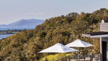 Ein Balkon mit Seeblick und Bergblick, mit Gartenmöbeln und einer Pergola.