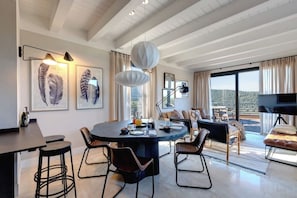 A modern dining area with a round table, chairs, and artwork on the walls.