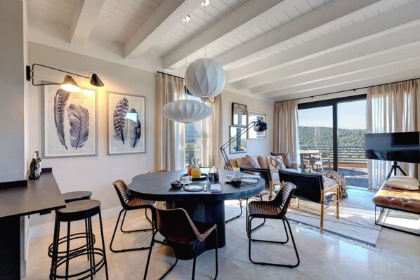 A modern dining area with a round table, chairs, and artwork on the walls.