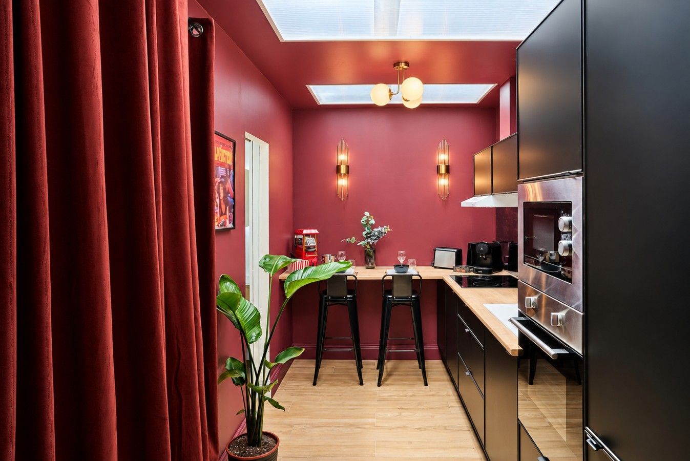 Cuisine équipée — comptoir et deux tabourets, four, micro-ondes et puits de lumière