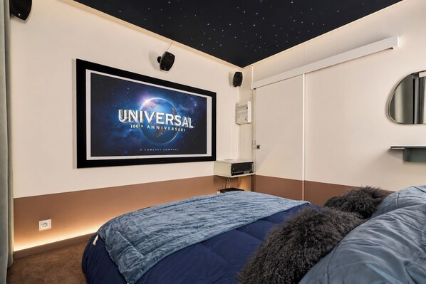 A bedroom with a bed, a framed picture on the wall, a ceiling light, and a wall-mounted air conditioning unit. - Vrbo Property (Armentières)
