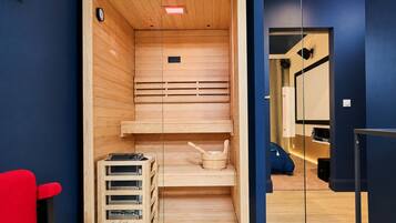 Un sauna avec des bancs en bois, une horloge et une petite table sur laquelle sont posés divers objets.