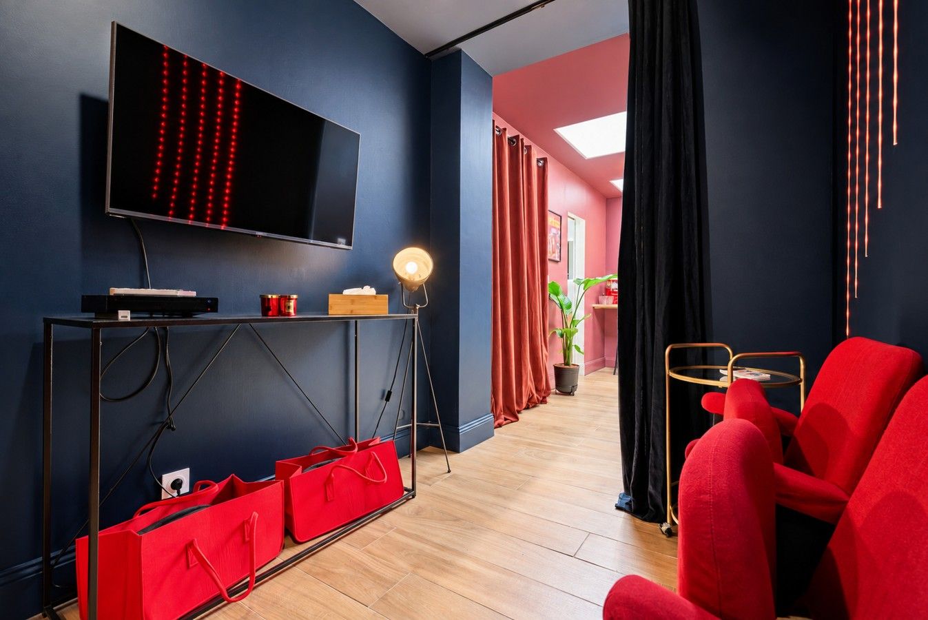 Salon — télévision, console et passage vers la cuisine