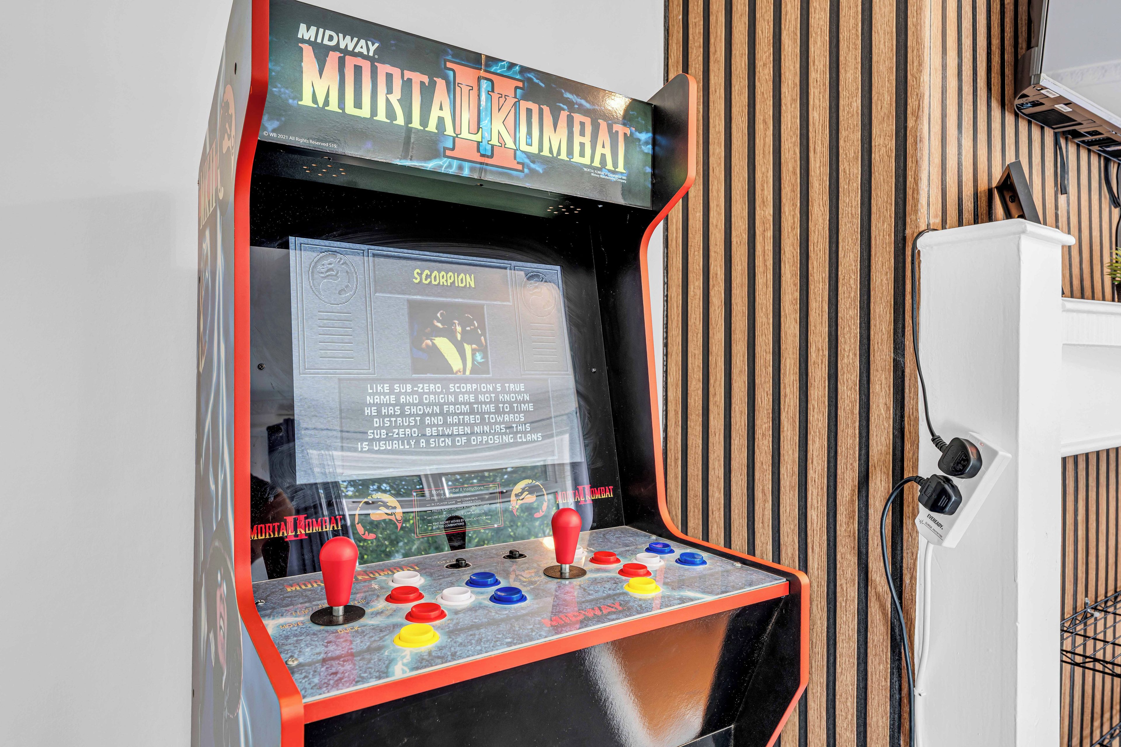 A vintage arcade machine for Mortal Kombat II with a control panel and instructions.