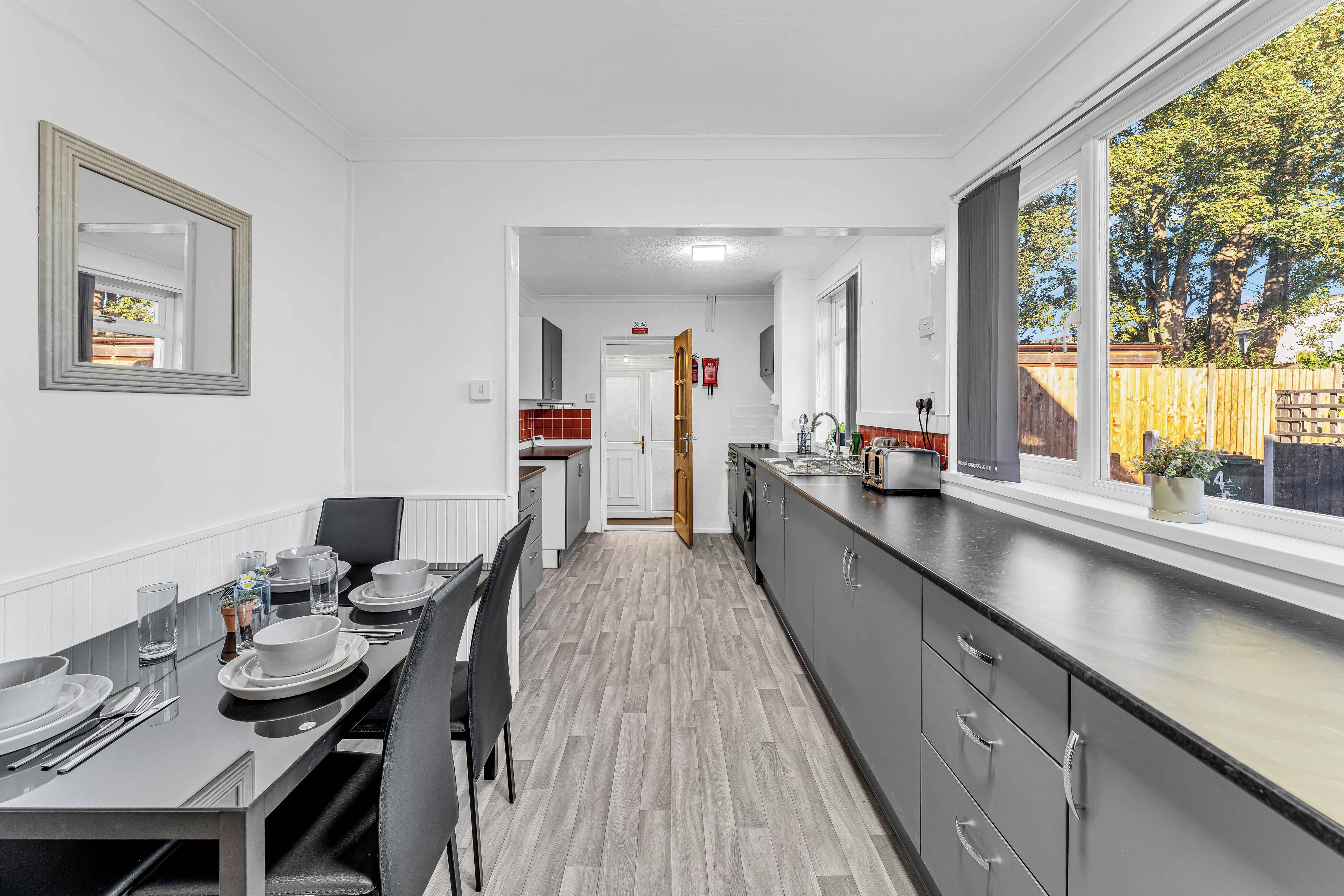 Una cocina moderna con comedor, ventanas amplias y vistas al exterior.