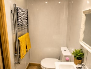 Ein kleines Badezimmer mit Toilette, Waschbecken und Handtuchhalter.