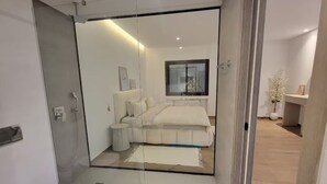 Een moderne slaapkamer met een groot bed, nachtkastjes en een raam.