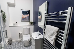 Ein modernes Badezimmer mit Toilette, Waschbecken und Handtuchhalter.