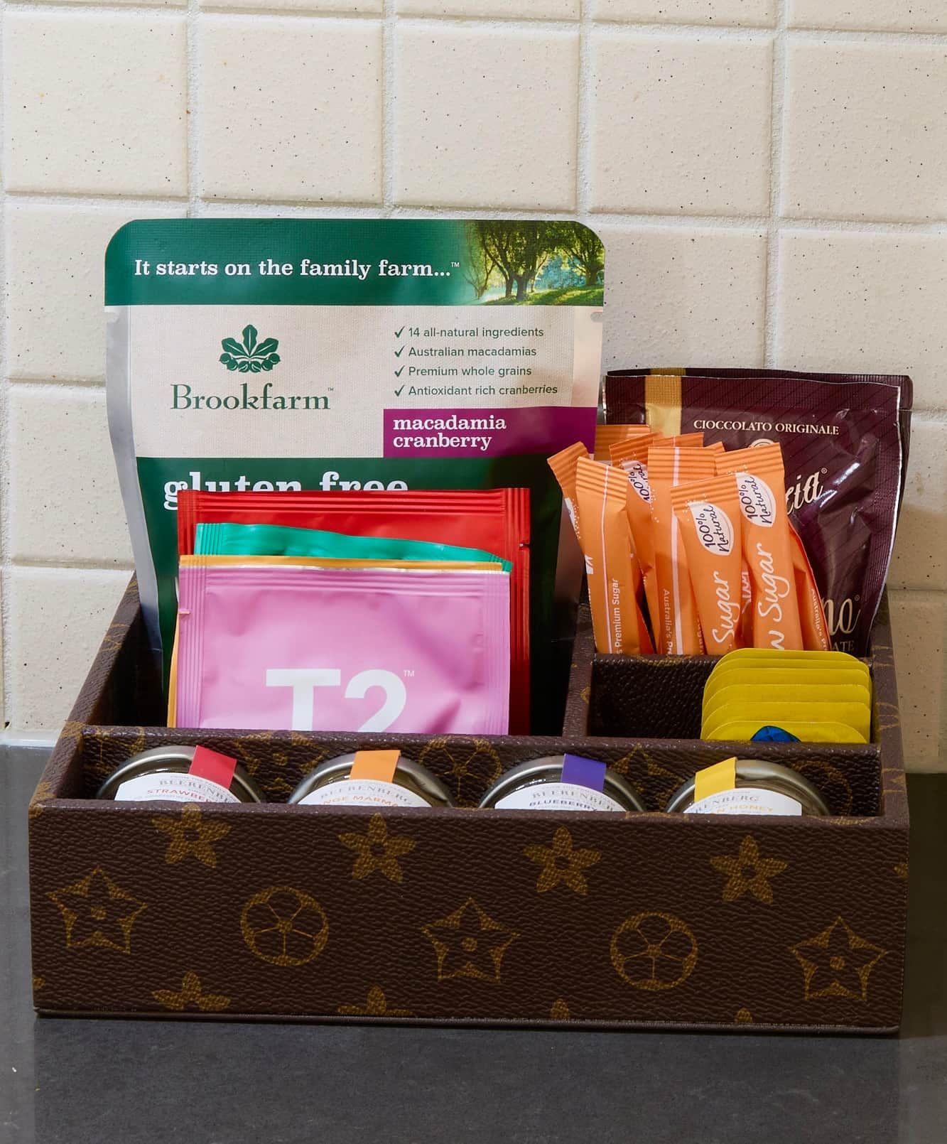 A gift box with various food items including gluten-free products, macadamia cranberry, and sugar packets.