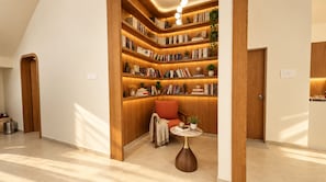 A modern interior with a built-in bookshelf, a cozy seating area, and a small table.