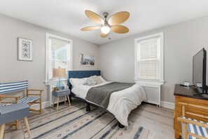 A bedroom with a bed, a desk, a chair, a ceiling fan, and a window with blinds. - Spacious 6BR Retreat Steps from Beach & Boardwalk (Wildwood Crest)