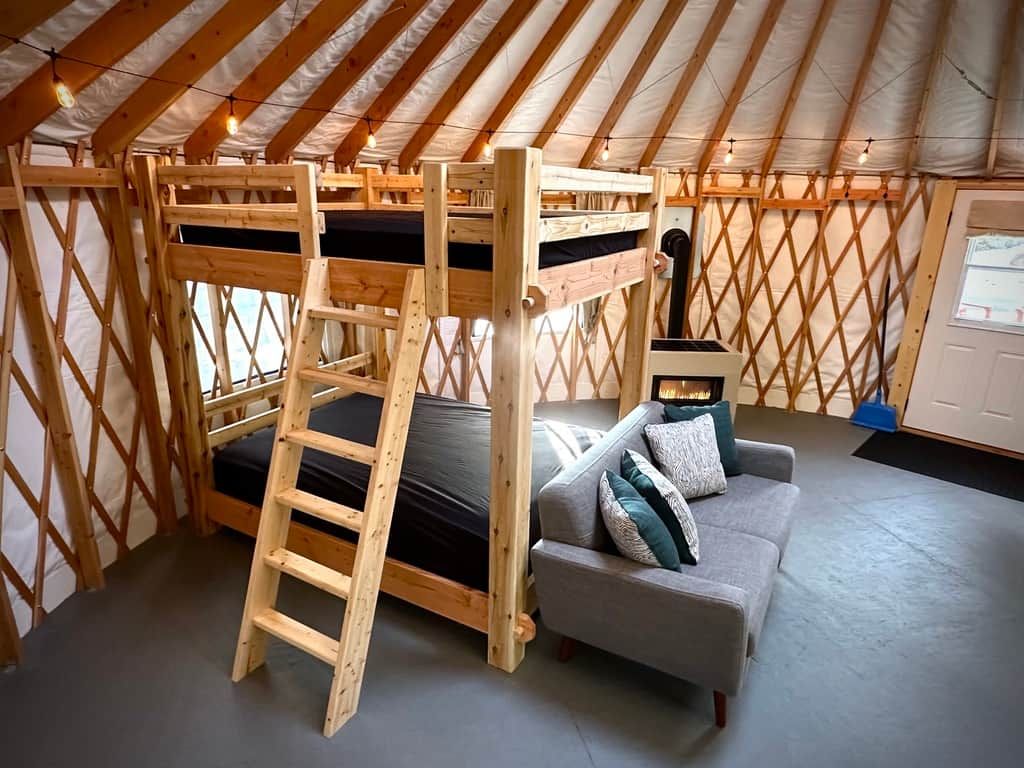 Um interior aconchegante com uma cama beliche, um sofá e uma lareira.
