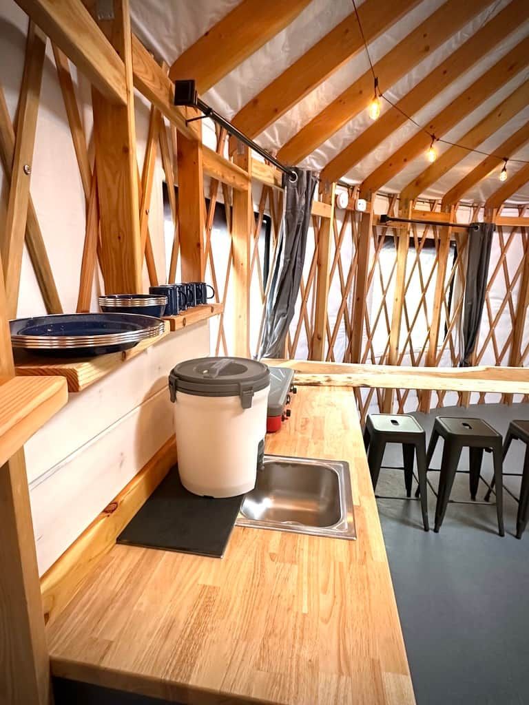 Een compacte keuken met houten balken, een spoelbak en een klein aanrecht.