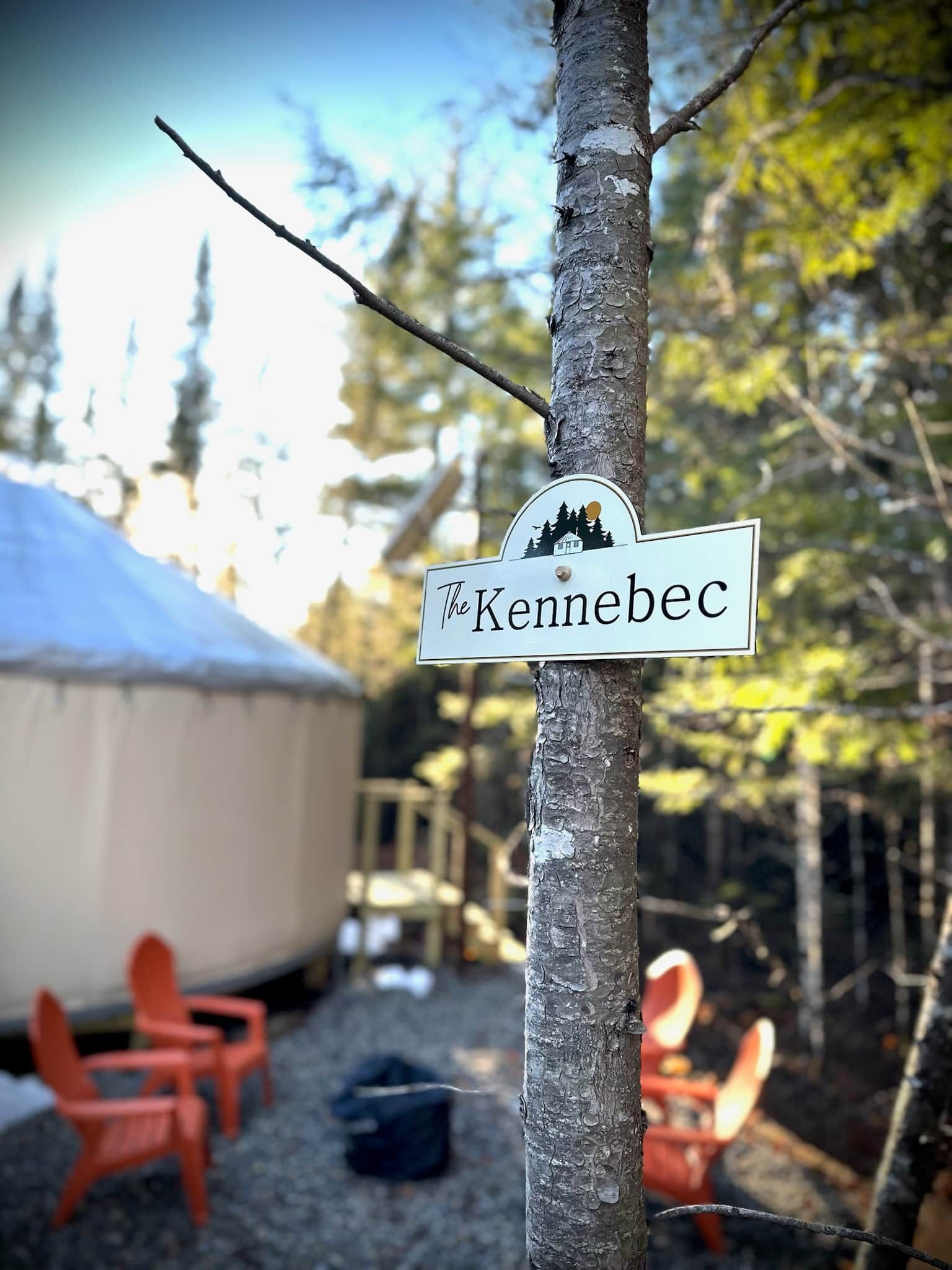 A sign with the name 'The Kennebec' attached to a tree.