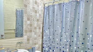 A bathroom with a white sink, toilet, and a shower curtain with a polka dot pattern. - 3-Bedroom Apartment 20 Minutes from AILA and the Colonial District (Santo Domingo Este)