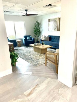 A modern living room with a sofa, coffee table, and a large window. - One Bedroom Condo with amazing Bayviews #504 (Fort Myers Beach)