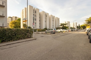 Una calle con coches aparcados, una señal de prohibido pasar y edificios residenciales.