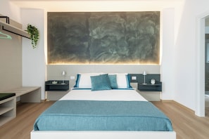 A modern bedroom with a large bed, bedside tables, a hanging plant, and a large abstract painting on the wall. - CordiAle Suites Pisa (Pisa)