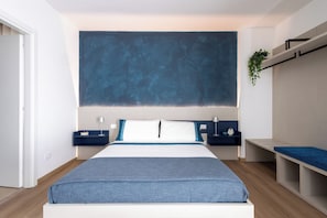Un dormitorio moderno con una cama grande, mesitas de noche, una planta colgante y estanterías empotradas.