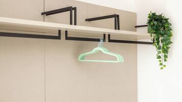 A wall-mounted rack with a single green hanger.