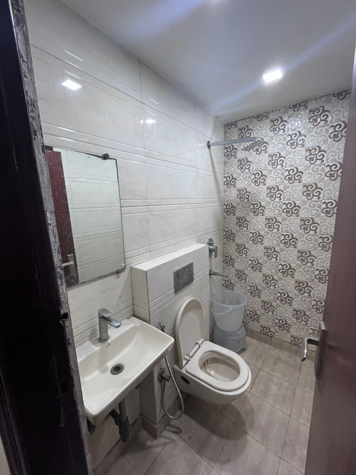 Un baño con inodoro, lavamanos y espejo.