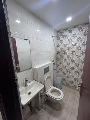 Casa de banho com sanita, lavatório e espelho.