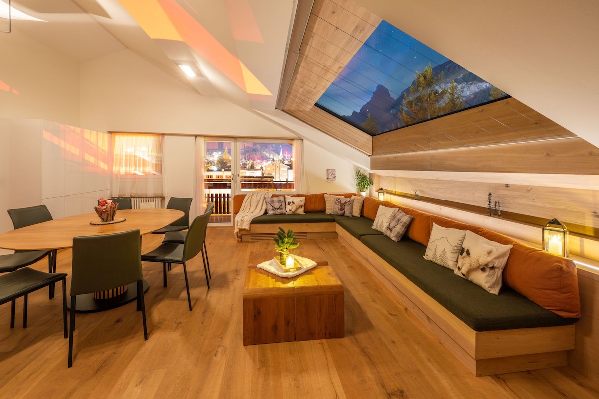A modern interior with a dining area, a sofa set, and a skylight.