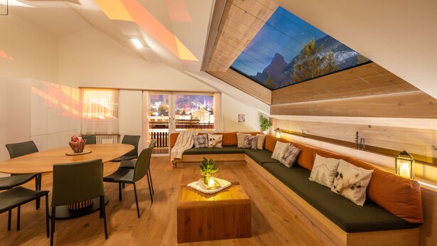 A modern interior with a dining area, a sofa set, and a skylight. - Sky Penthouse with matterhorn view (Zermatt)