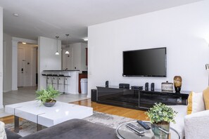 A modern living room with a flat-screen TV, a glass coffee table, and a sofa. - Vista Cay near Epic Apartment remodeled (Orlando)