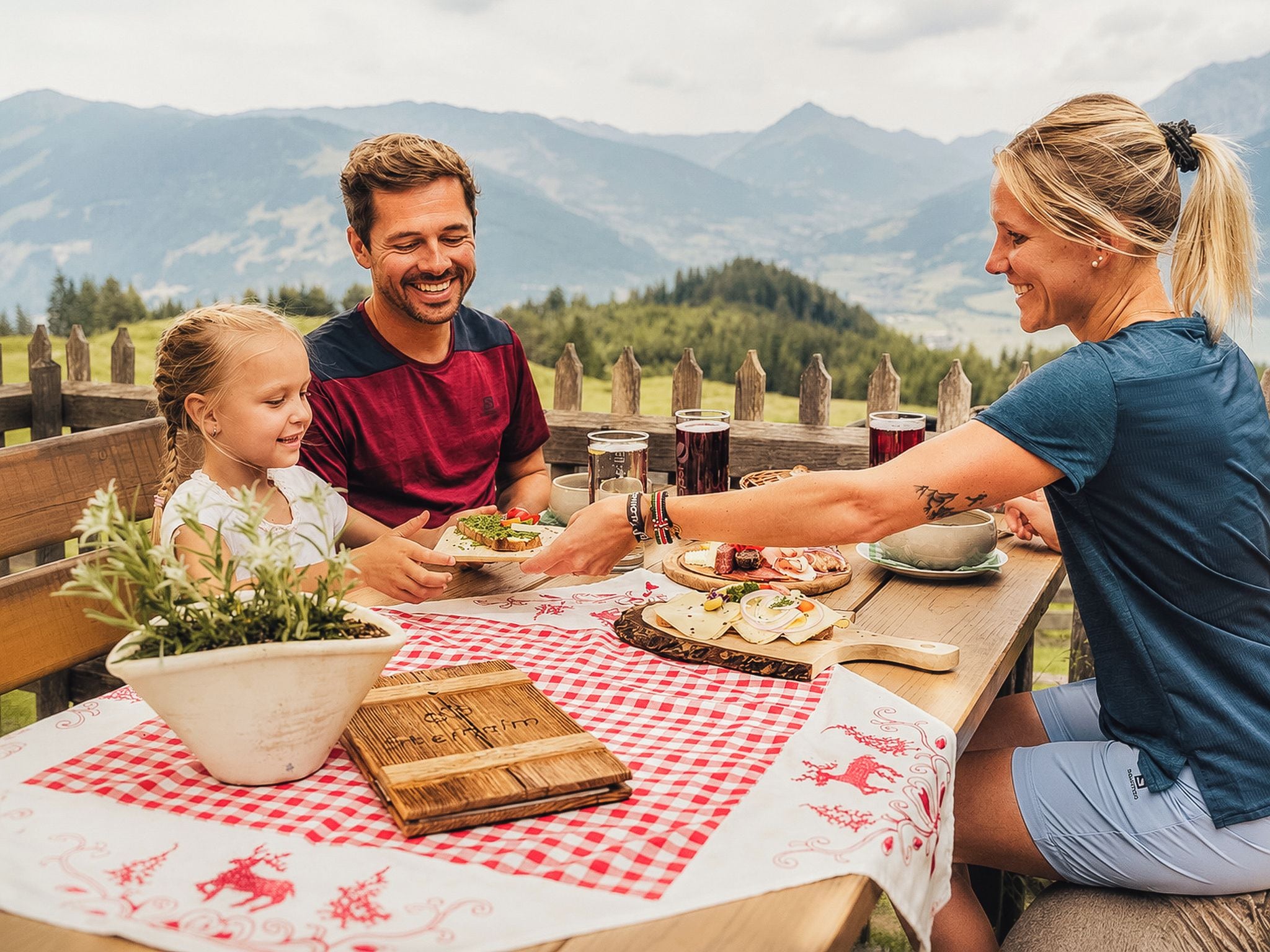 Eine Familie isst draußen mit Blick auf die Berge.
