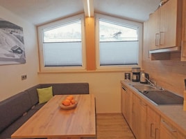 Una cocina funcional con comedor, muebles de madera y una ventana con persianas.