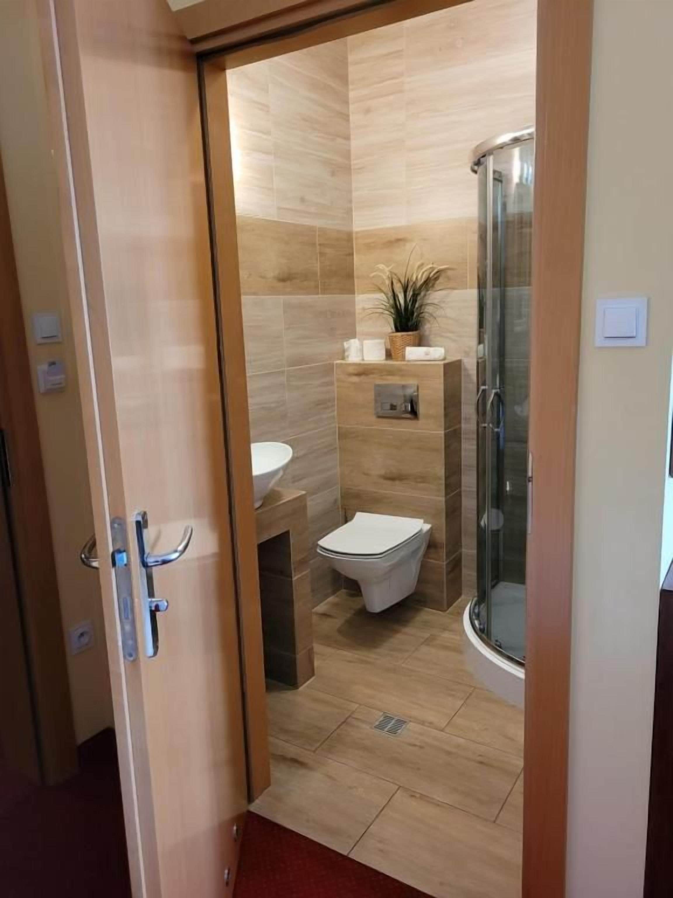 Un baño moderno con cabina de ducha de vidrio, inodoro y lavamanos.