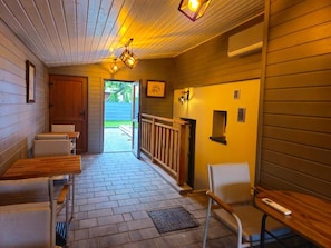 A wooden interior with a bench, a door, and a window.