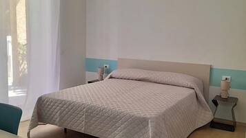 Une chambre à coucher avec un lit, une table de chevet et une chaise.