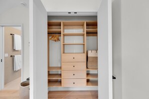 Ein begehbarer Kleiderschrank mit zahlreichen Regalen, Schubladen und Ablageflächen zum Aufhängen.