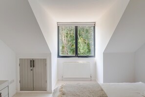 A bedroom with a skylight, a radiator, and a wardrobe. - Palm Beach House | 5 Bed by Pett Level Beach - Pass the Keys (Hastings)