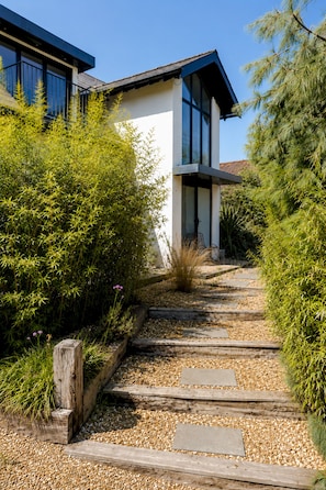 A modern building with a stone pathway leading to the entrance. - Palm Beach House | 5 Bed by Pett Level Beach - Pass the Keys (Hastings)