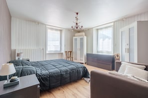 Ein Schlafzimmer mit Bett, Stuhl, Schreibtisch und Kleiderschrank.