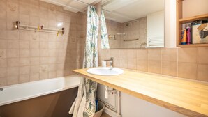 Ein Badezimmer mit Badewanne, Waschbecken und Spiegel.