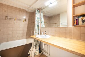 Ein Badezimmer mit Badewanne, Waschbecken und Spiegel.