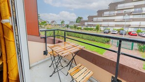 Een balkon met uitzicht op een woongebied, een tafel en een stoel.