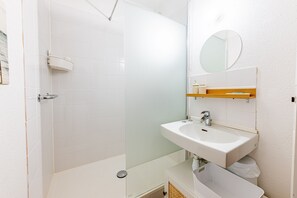 Ein modernes Badezimmer mit Dusche, Waschbecken und Spiegel.
