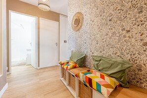 Ein Zimmer mit einer Bank, einer Tür und einem Wandpapier mit Muster.
