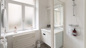 A bathroom with a window, a shower, a sink, and a toilet. - La Croix du Fief - Dans Intra Muros (Saint-Malo)