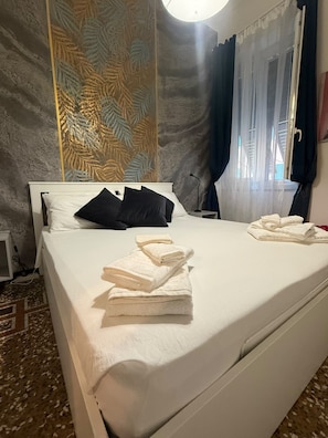 A hotel room with a bed, pillows, a lamp, and towels. - Spacious 4-bedroom apartment in delightful Genova with AC (Genova)