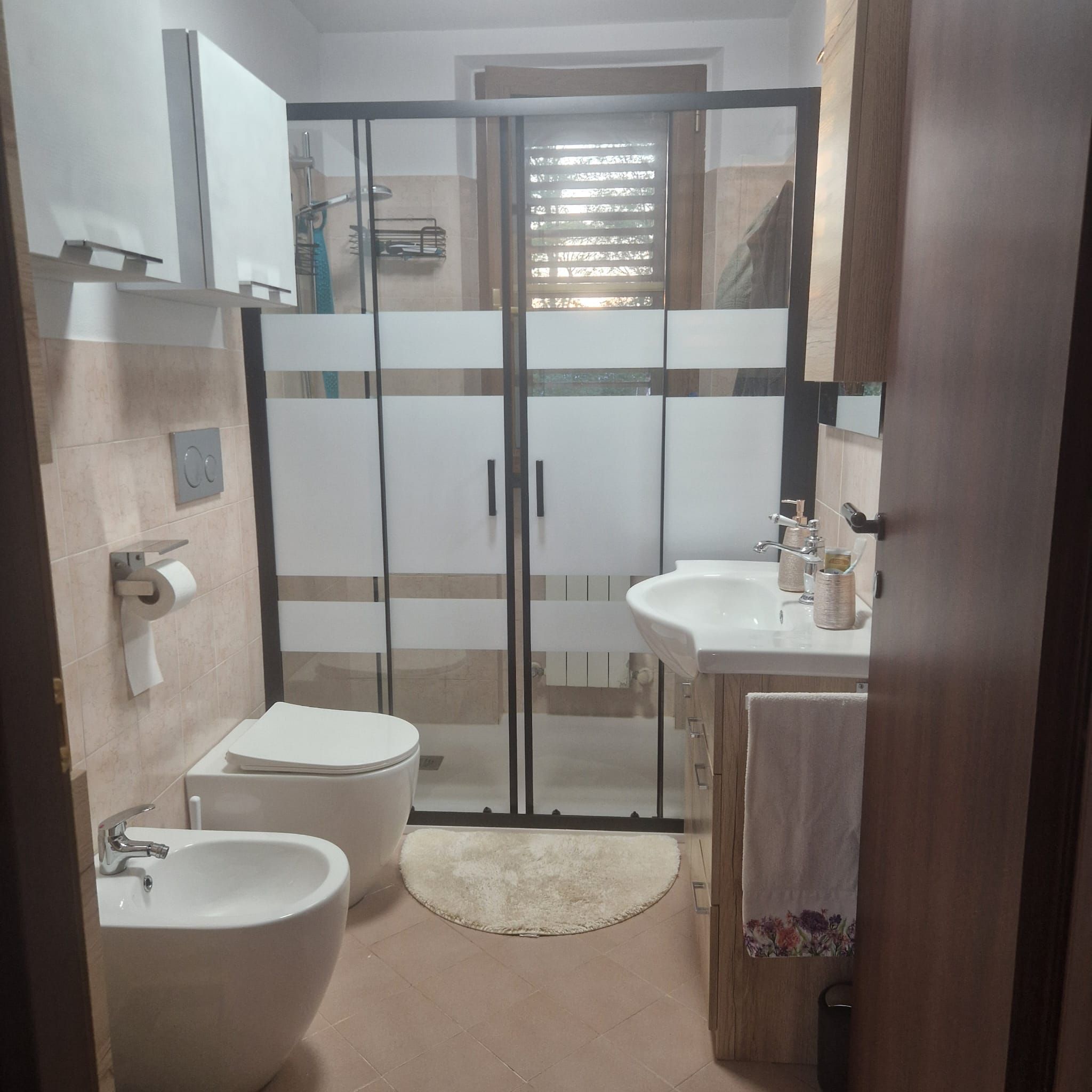 Ein modernes Badezimmer mit Toilette, Bidet und Waschbecken.