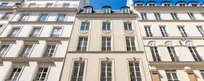 En række høje bygninger med ensartet arkitektur, med altaner og store vinduer.