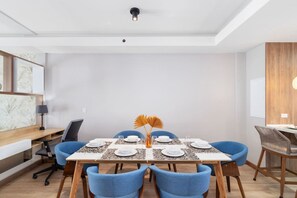 A dining area with a table set for four, blue chairs, and a decorative centerpiece. - LUX 1BR House Pool Gym 7-Min Walk Palm Beach - Porta Al Sole 8 by Bocobay (Noord)
